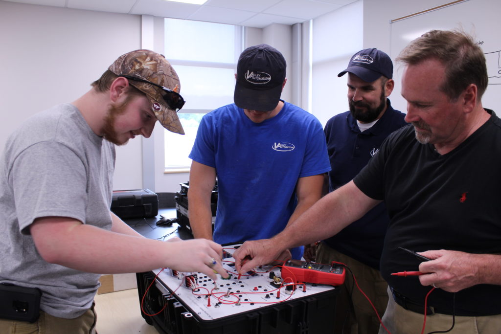 Students and instructor use mechatronics training equipment