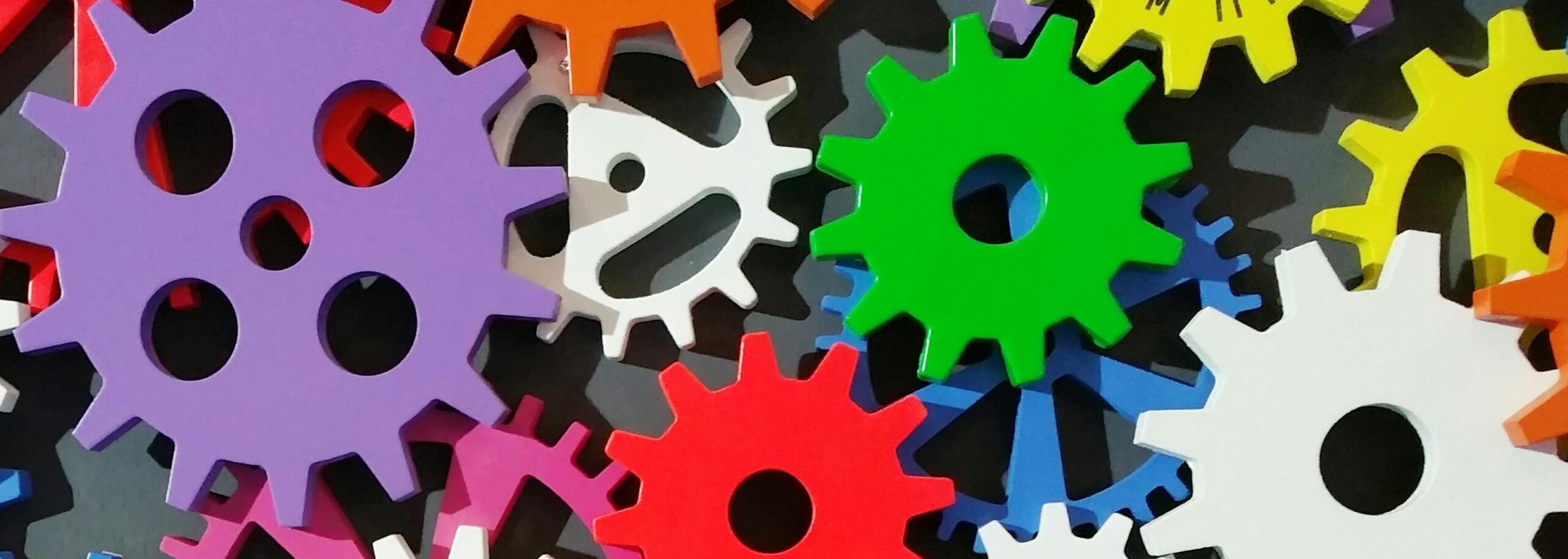 an image of several multi-color gears within a mechanical device