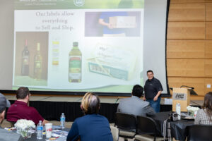 A man stands in front of a crowd and gives a presentation on lean systems