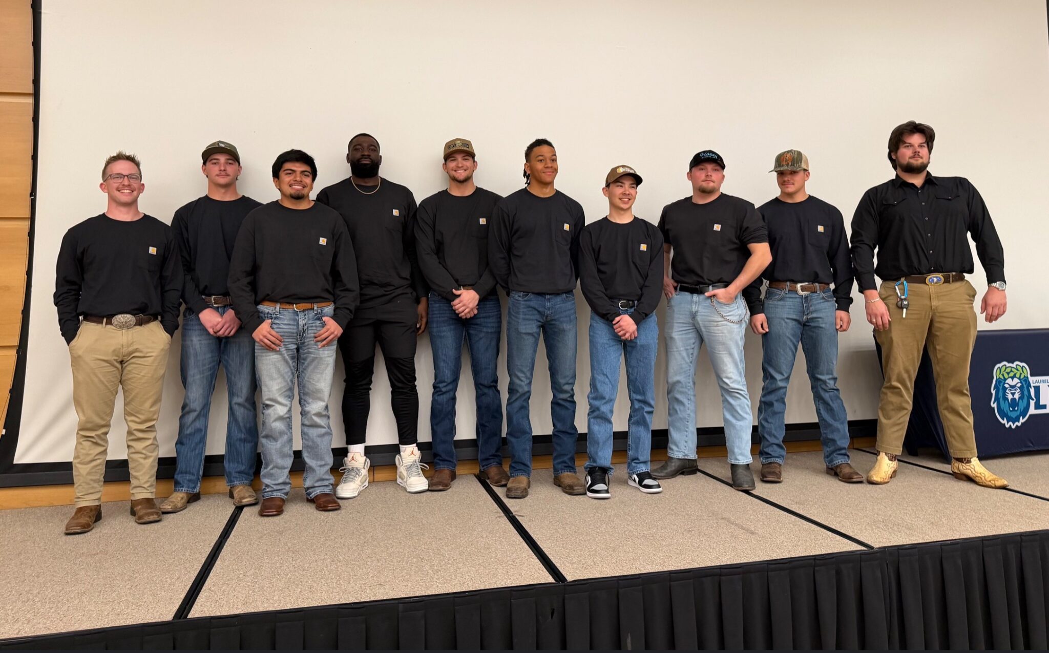 a group of men standing on stage smiling at the viewer