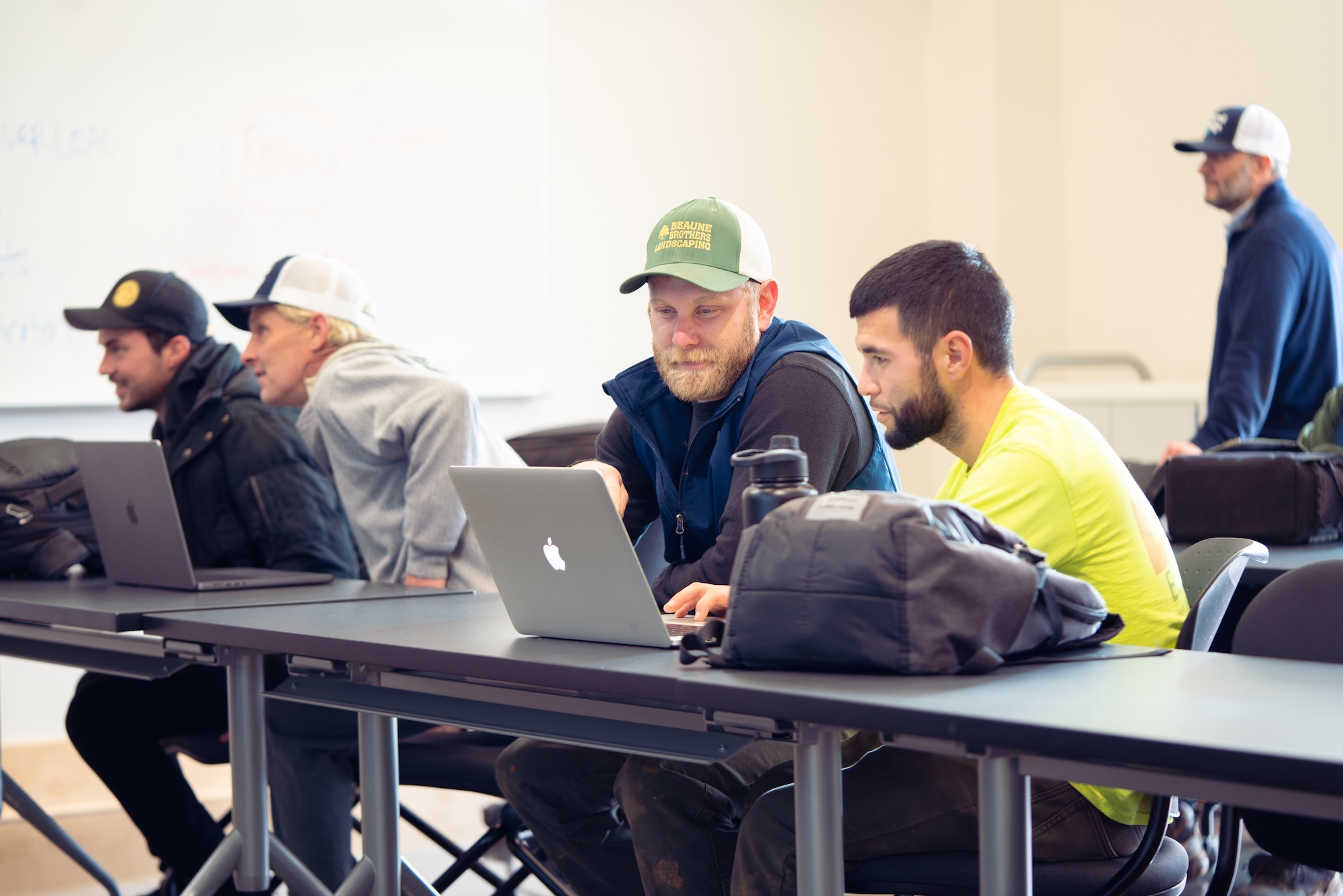 Two students using a laptop in a classroom setting