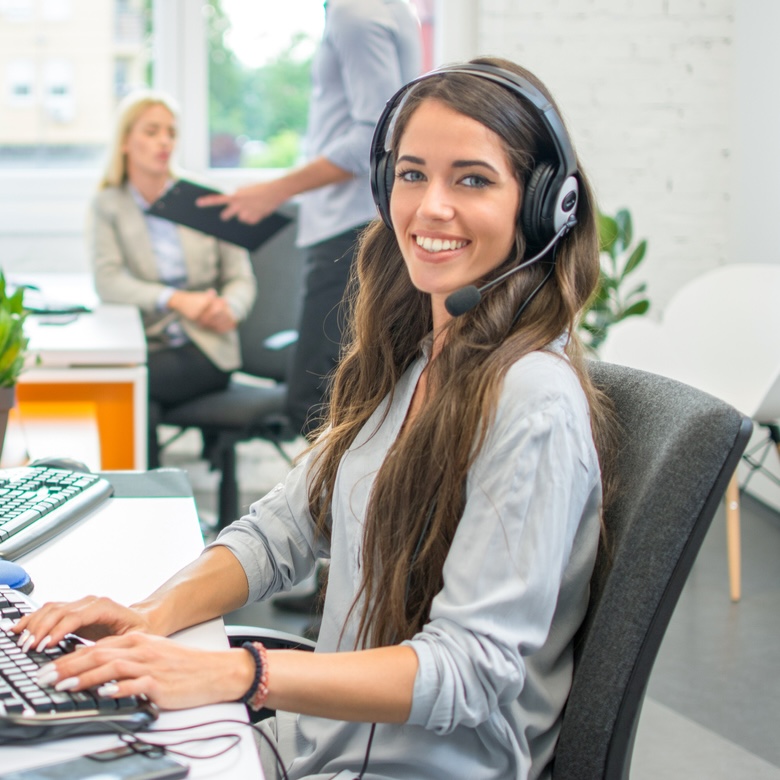 Computer-User-Support a woman smiling while sitting at a computer
